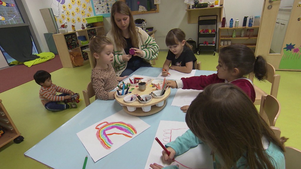 Foto: Eine Kita-Beschäftigte betreut eine Gruppe von Kindern