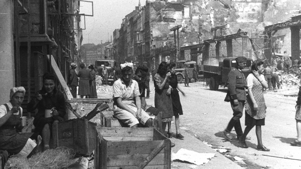 Foto: Menschen in einer zerbombten Straße im 2. Weltkrieg