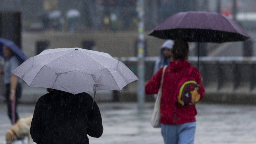 Passanten mit Regenschirmen unterwegs in der Stadt