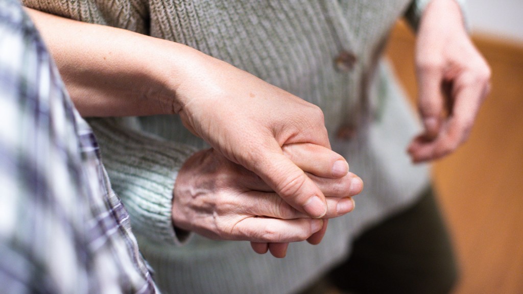 Junge Frau hält alte Frau an der Hand