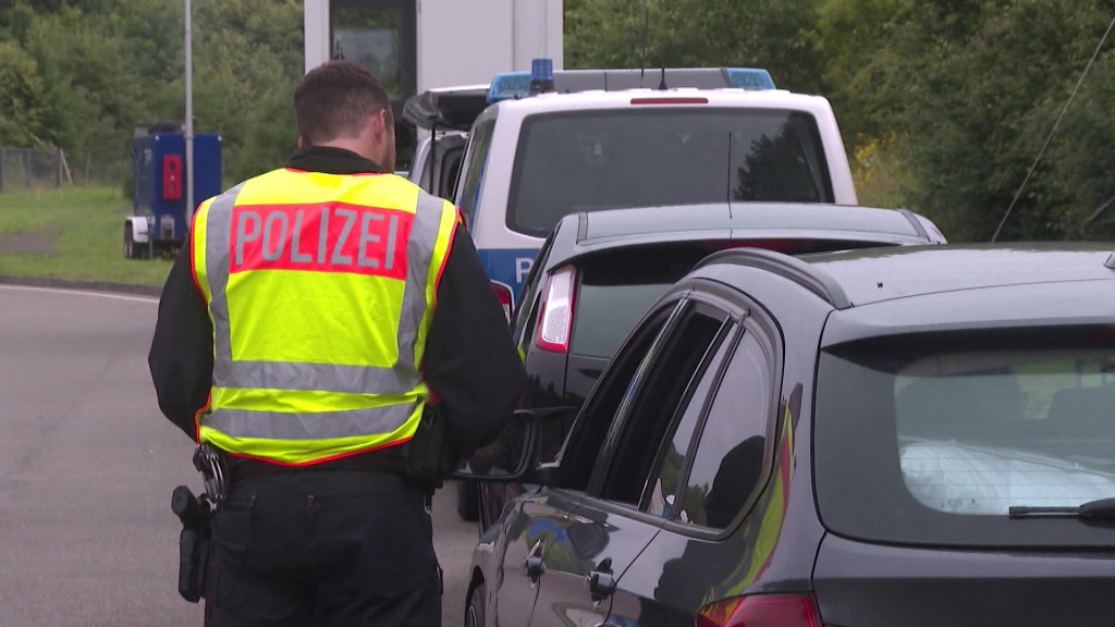 Polizist bei der Kontrolle von Autos an der Grenze