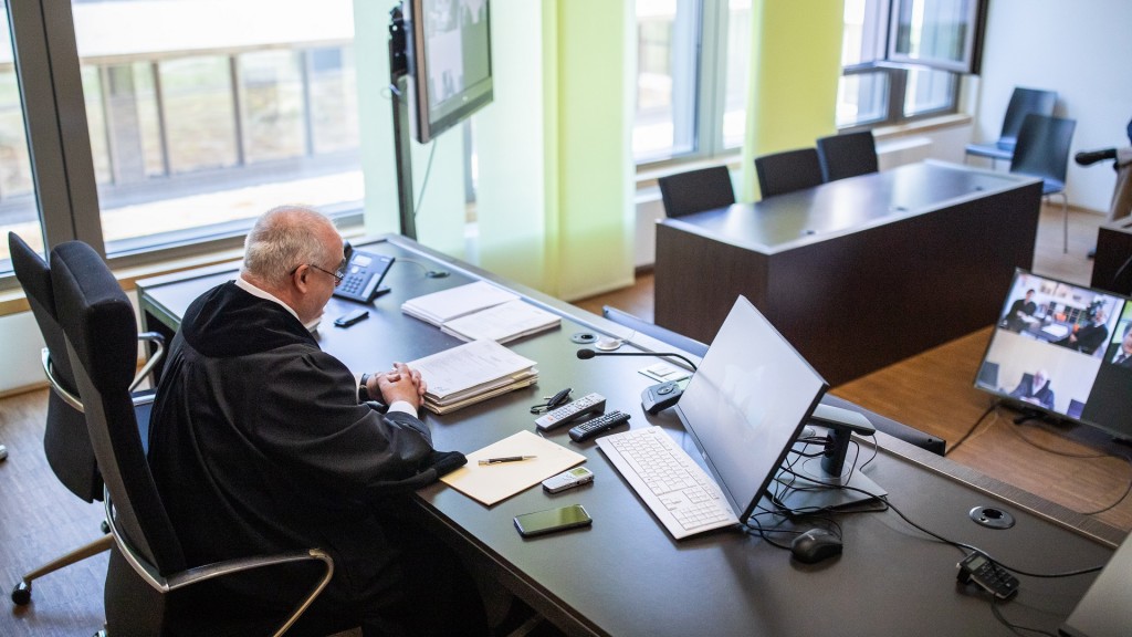 Foto: Ein Richter sitzt während einer Online-Verhandlung vor einem Bildschirm.