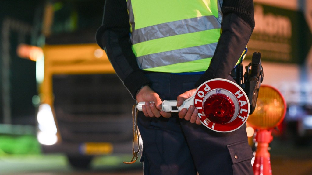 Polizist bei der Kontrolle von Autos an der Grenze