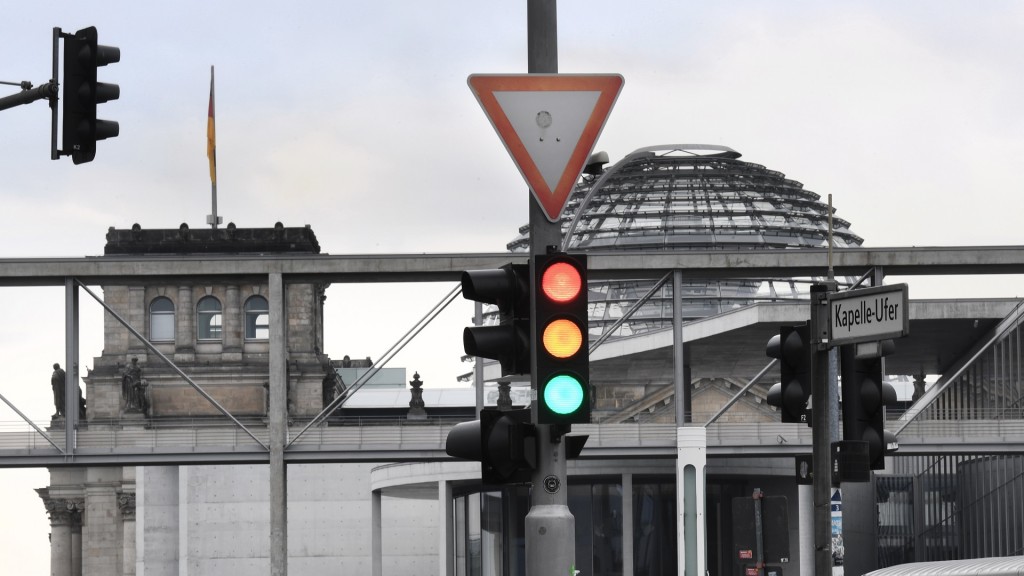 Eine Ampel, an der für einen Moment die Farben Rot, Gelb und Grün gleichzeitig leuchten