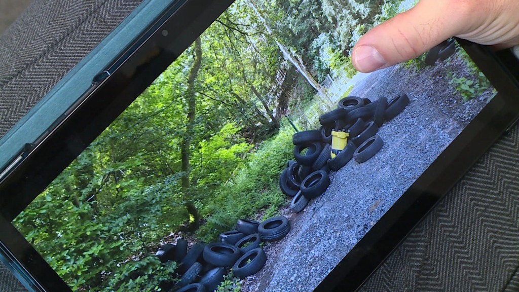 Foto: Bild auf einem Tablet - im Wald entsorgte Altreifen