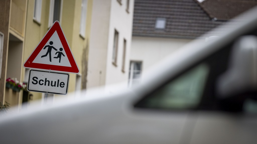 Hinter einem PKW ist ein Schild mit dem Schriftzug 