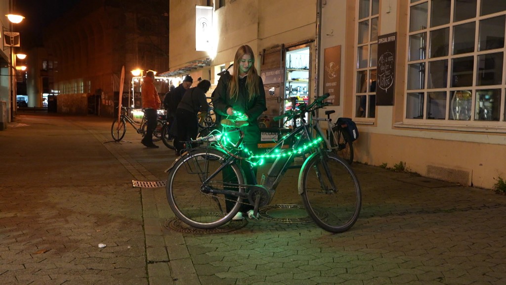 Foto: Eine Fahrradfahrerin mit einer Lichterkette an ihrem Rad