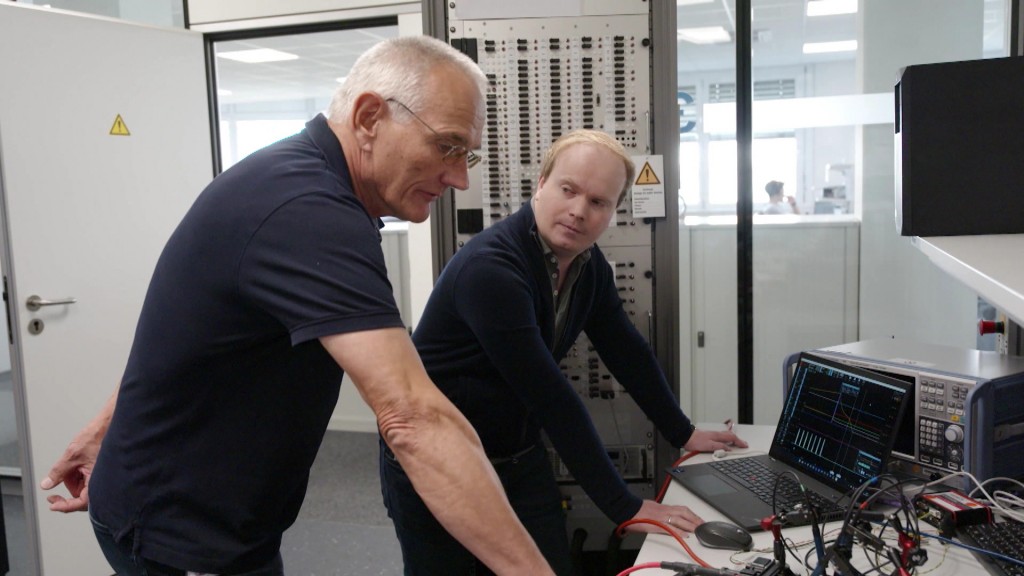 Foto: Ein älterer Herr und sein jüngerer Kollege bei der Arbeit