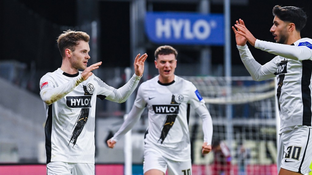 Elversbergs Tom Zimmerschied (l) bejubelt sein Tor zum 1:1 mit Muhammed Damar (r) und Fisnik Asllani.