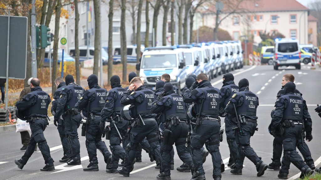 Mehrere Polizeibeamte laufen über eine Straße.