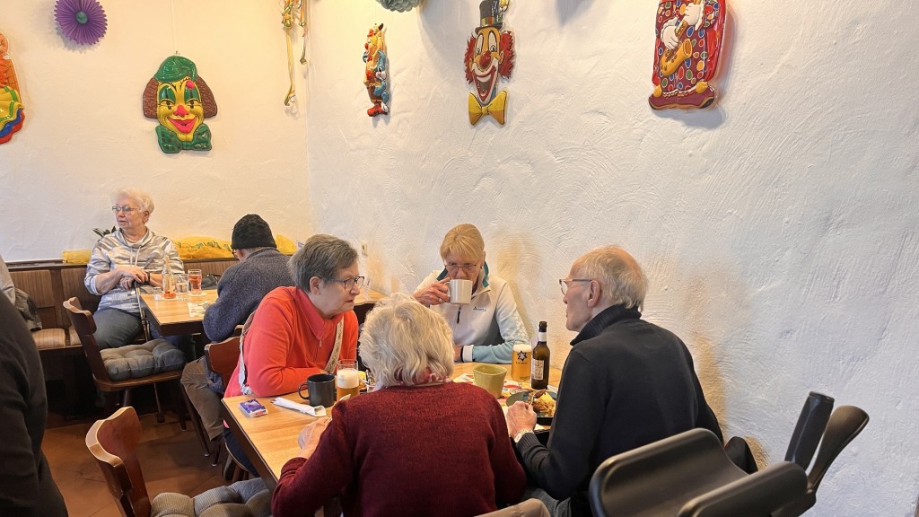 Besucher sitzen an Tischen im Dorf-Treff in Wellesweiler