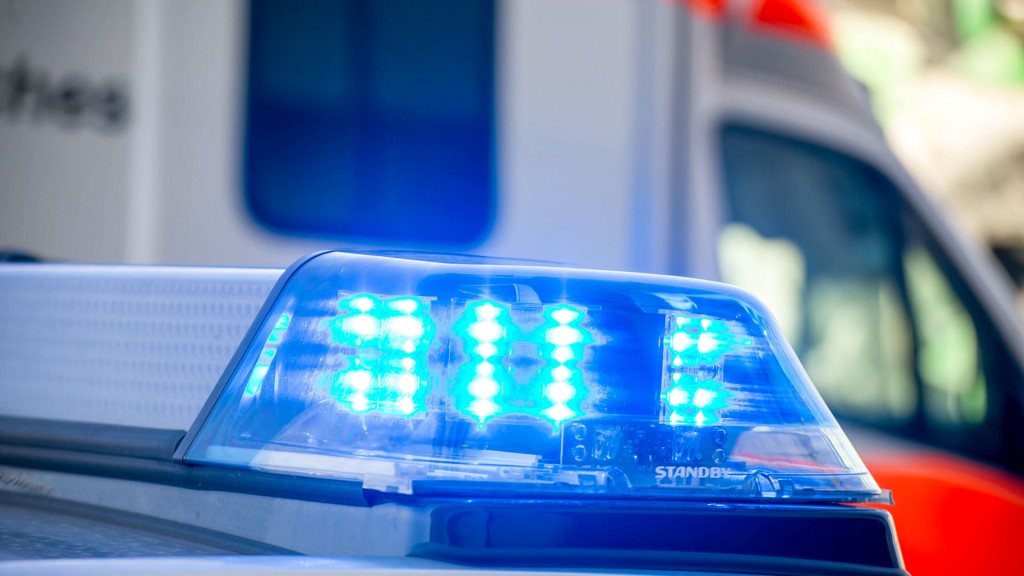 Blaulicht eines Polizeiwagen vor einem Fahrzeug des Rettungsdienstes