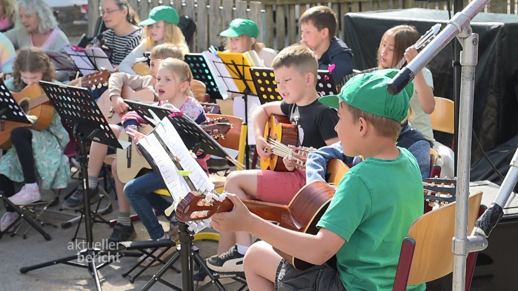 Foto: Kinder singen und spielen Instrumente auf der Bühne