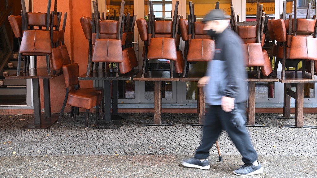 Foto: Ein Passant geht an einen geschlossenen Lokal vorbei.