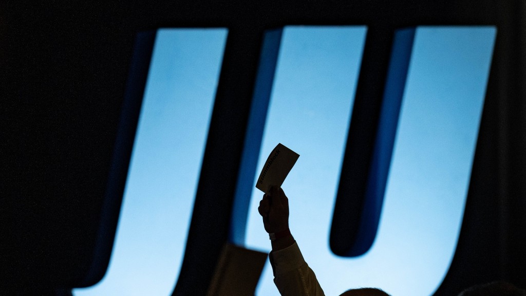 Foto: Delegierte heben auf einer Landesversammlung Union vor dem Logo der JU ihre Stimmkarten