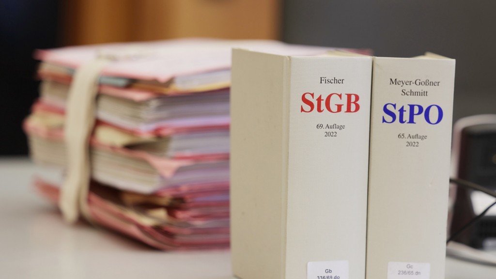 Gerichtsakten und Bücher zu Strafgesetzbuch und Strafprozessordnung liegen bzw. stehen liegen auf einem Tisch im Gericht