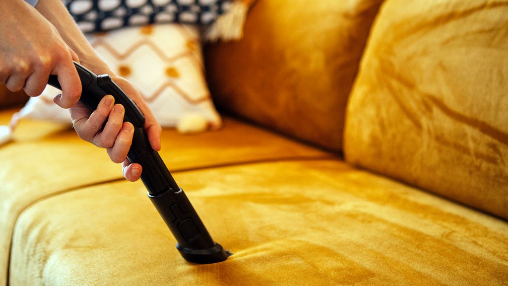 Jemand saugt ein Polstermöbel ab