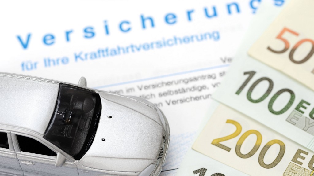 Kfz-Versicherungsschein und Miniaturauto, Symbolbild für  Kfz-Versicherungsbeiträge