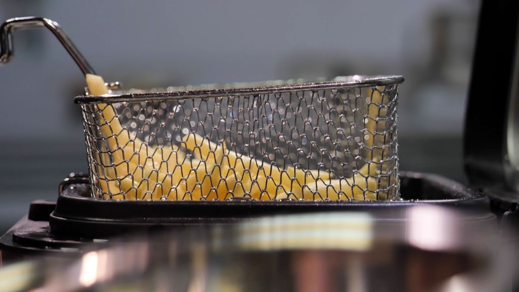 Foto: Pommes Frites werden aus einer Fritteuse gehoben