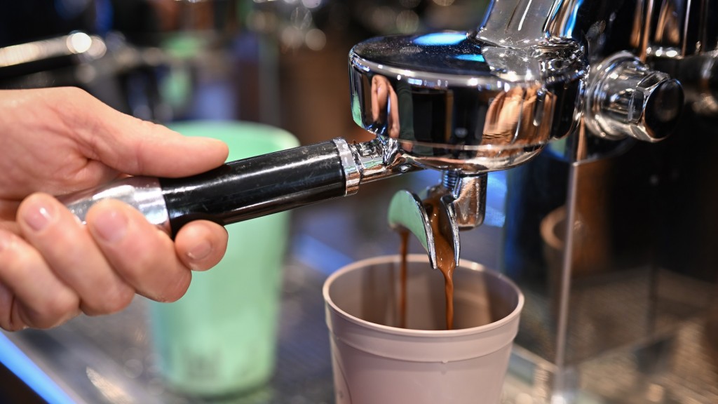 Foto: Ein Barista bereitet einen Kaffee zu, der in einen Mehrwegbecher fließt.