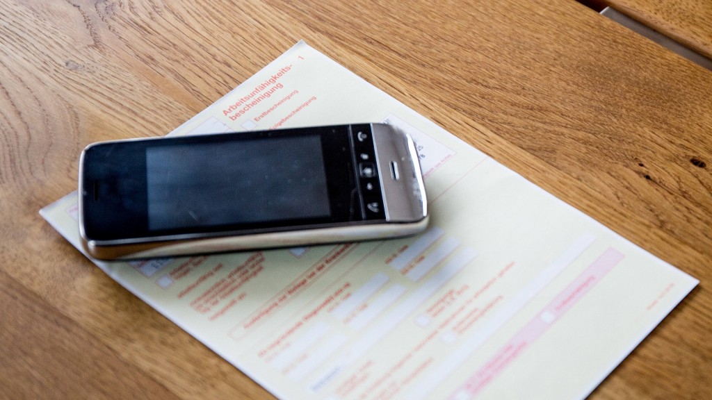 Foto: Ein Telefon liegt auf einer Arbeitsunfähigkeitsbescheinigung