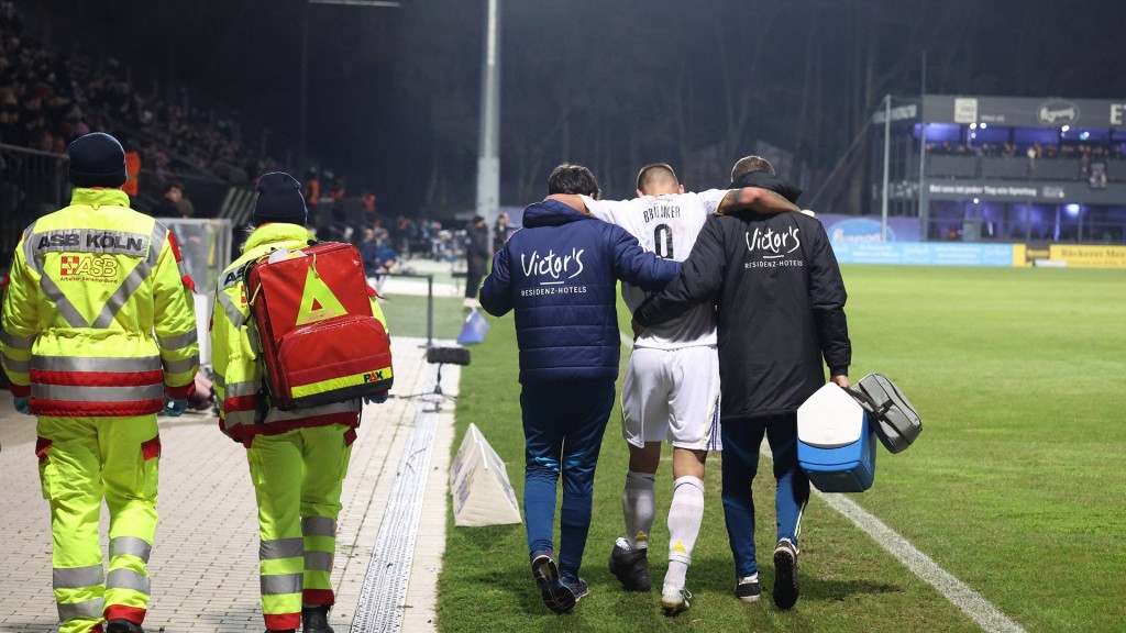 Im Spiel Viktoria Köln gegen 1.FC Saarbrücken Kai Brünker (1.FCS) verletzt. Betreuer stützen ihn.