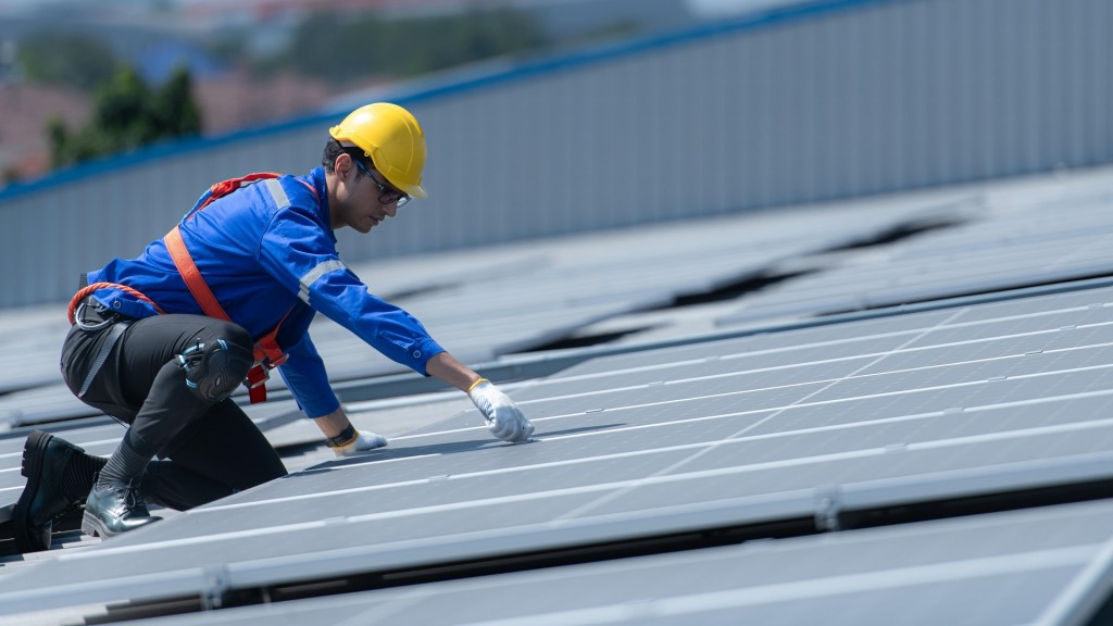 Ein Facharbeiter bei der Montage von Solarpanelen auf einem Dach.