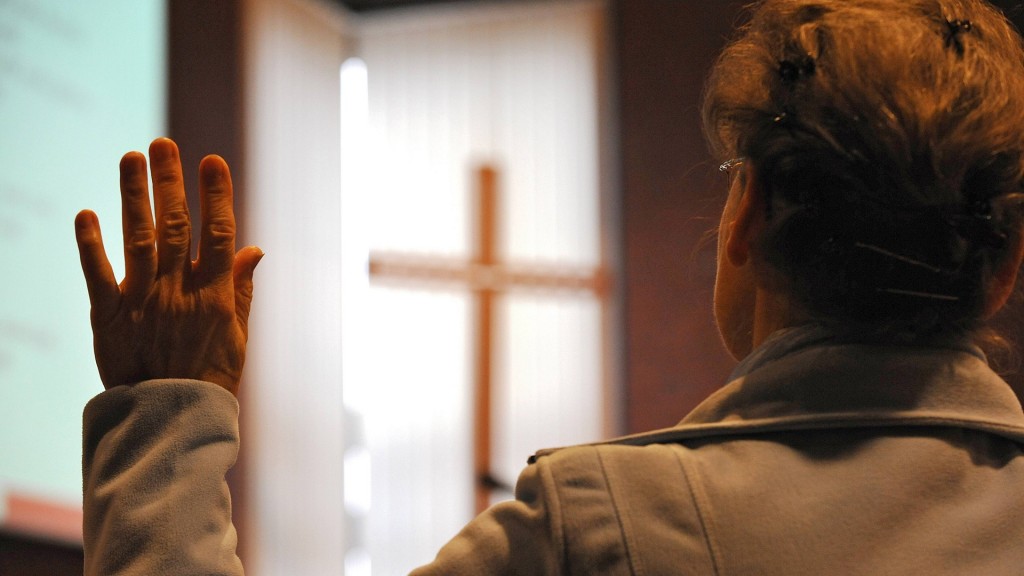 Frau hebt eine Hand während eines Gottesdienstes