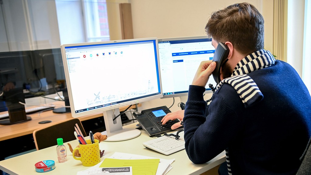 Foto: Mann sitzt vor Computer-Bildschirm und telefoniert.