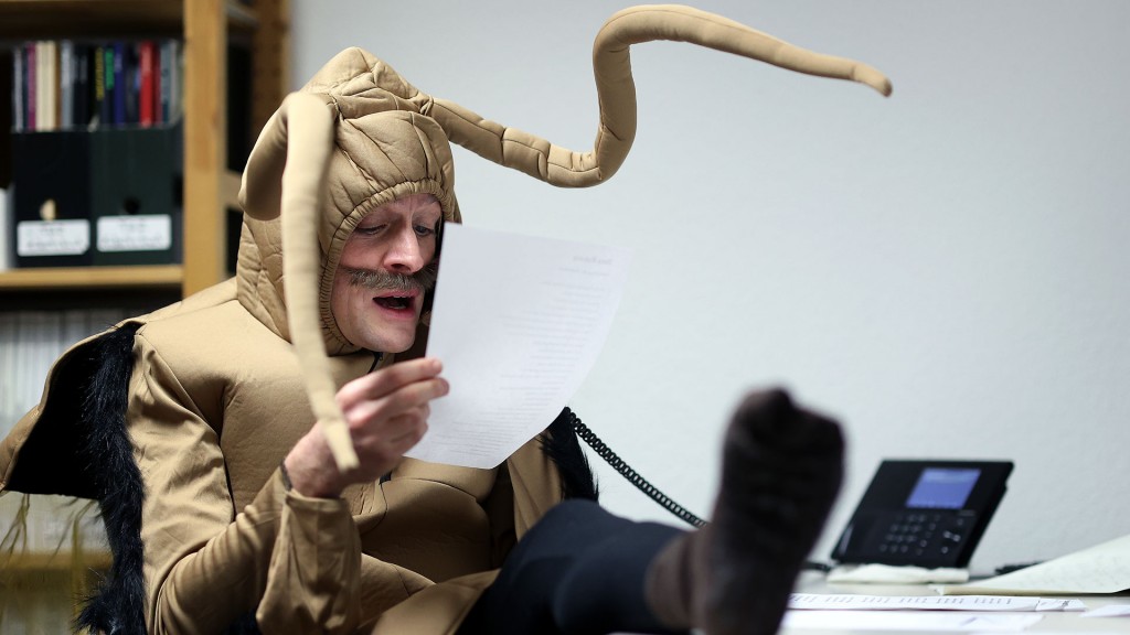 Ein Büroangestellter sitzt verkleidet am Schreibtisch und telefoniert