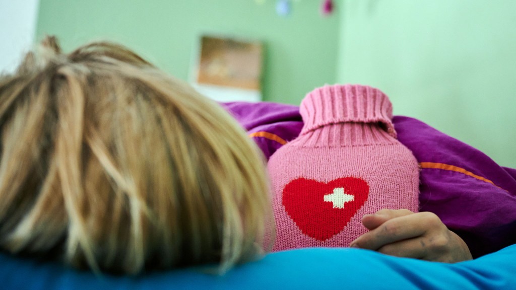 Foto: Ein krankes Kind liegt mit Wärmflasche im Bett