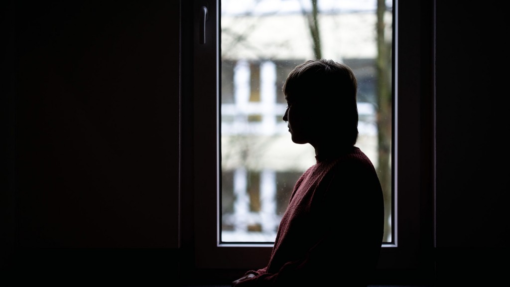 Foto: Frau schaut aus dem Fenster