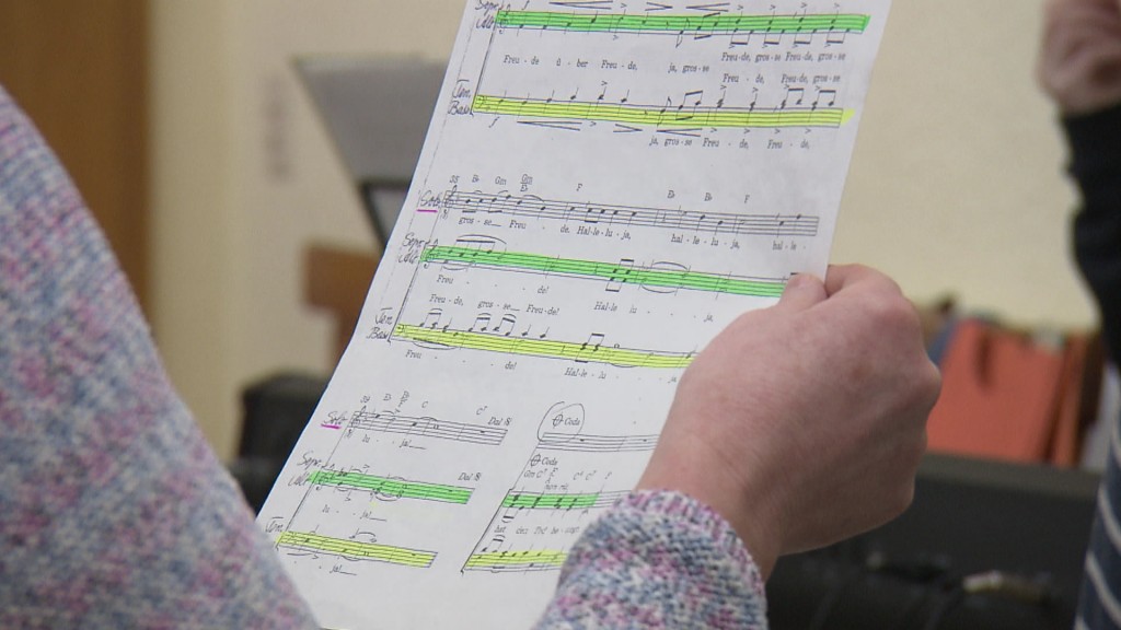 Foto: Eine Frau hält einen Notenzettel in der Hand