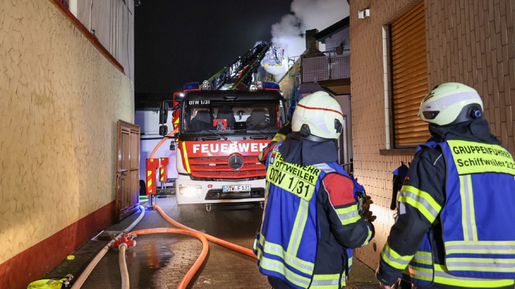 Einsatzkräfte der Feuerwehr löschen einen Wohnhausbrand in Schiffweiler.