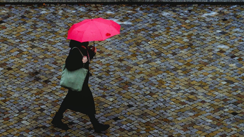 Eine Frau mit Regenschirm bei trübem Tageslicht