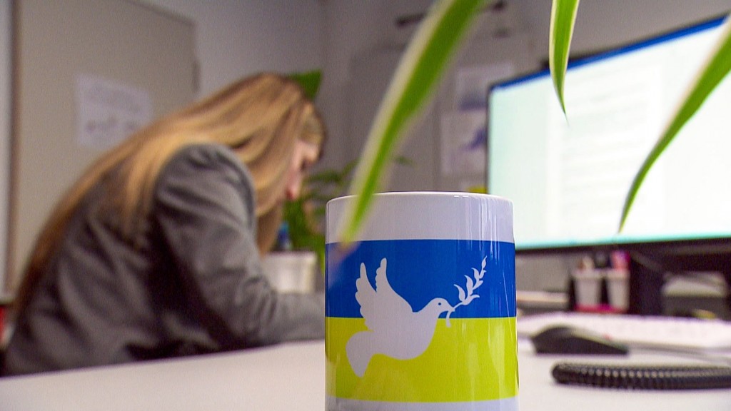Foto: Eine Kaffeetasser mit der ukrainischen Flagge und einer Friedenstaube steht auf einem Bürotisch