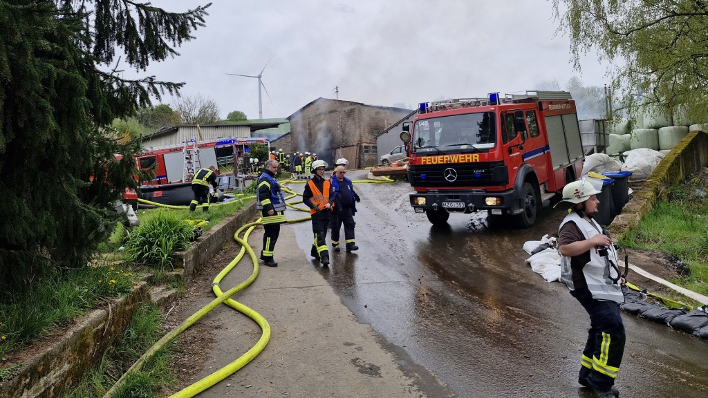 Foto:  Feuerwehrleute beim Löschen eines Strohballenbrandes in Losheim-Wahlen