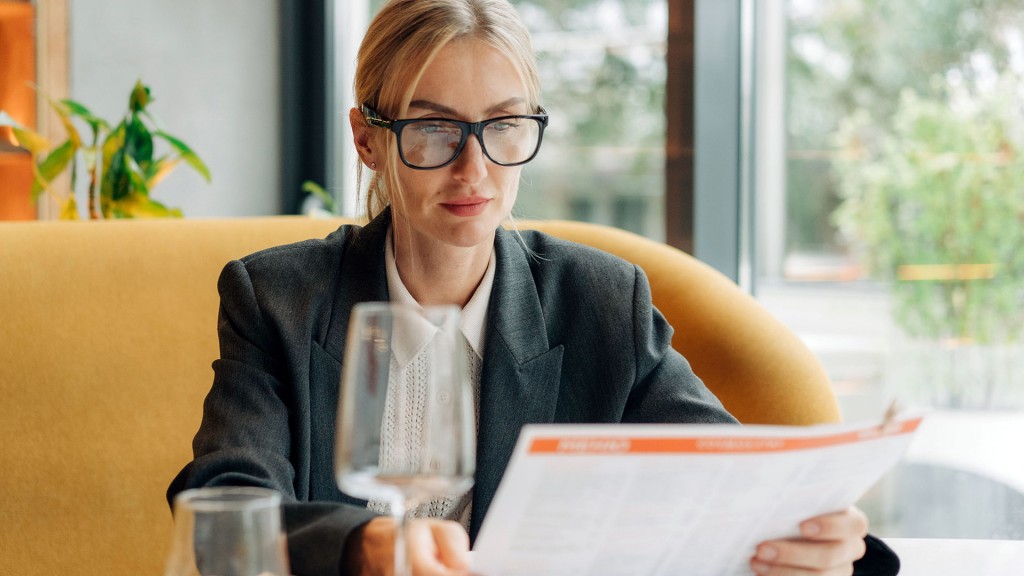Eine Frau sitzt in einem Restaurant und liest die Speisekarte