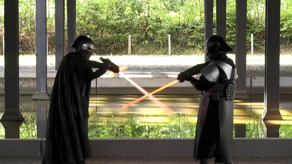 Menschen in Star Wars Kostümen kämpfen mit Laserschwerten