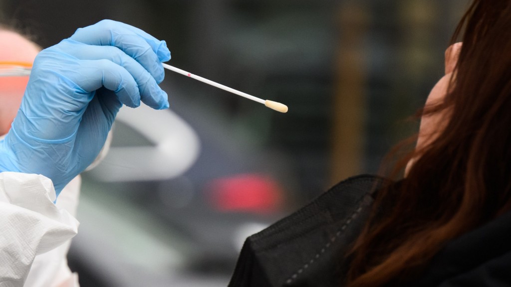 Foto: Eine Mitarbeiterin nimmt einen Abstrich von einer Patientin