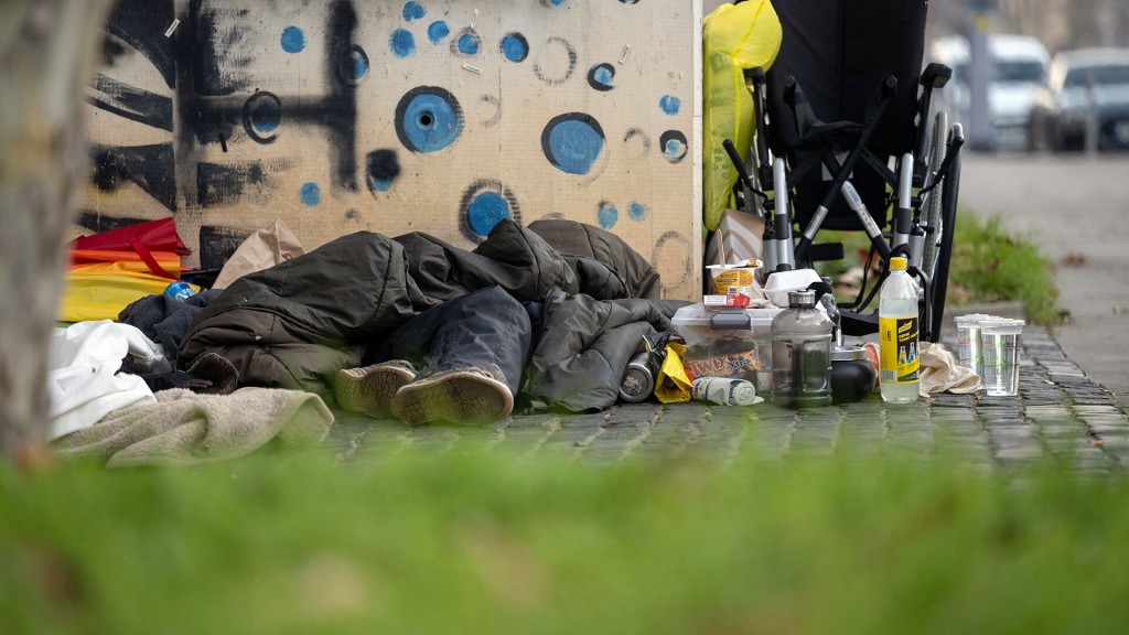 Ein Obdachloser liegt in der Innenstadt unter einem Schlafsack
