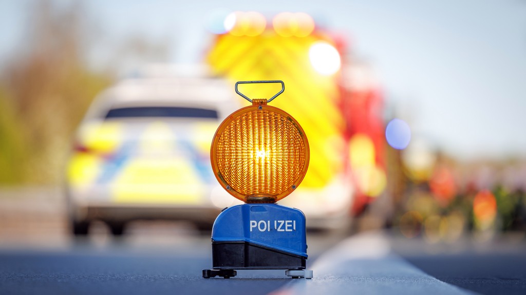 Eine Polizeiabsperrung steht vor Einsatz- und Rettungswagen