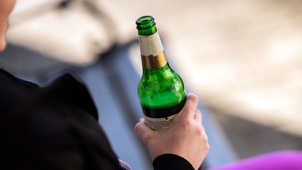 Junge Frau hält eine Bierflasche in der Hand