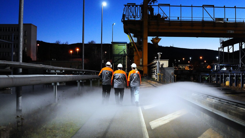 Metallarbeiter gehen über ein Firmengelände