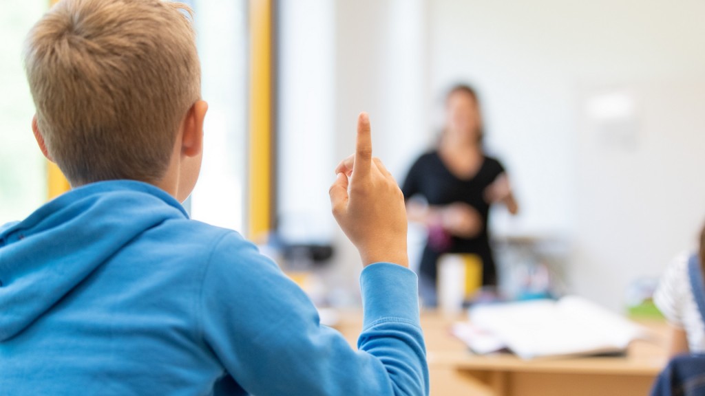 Eine Lehrerin unterrichtet Schüler einer Grundschule in einem Klassenraum.