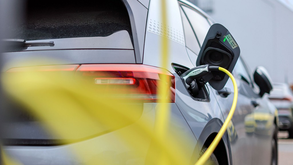 Foto: Ein Elektrofahrzeug mit einem gelben Kabel an einer Ladesäule