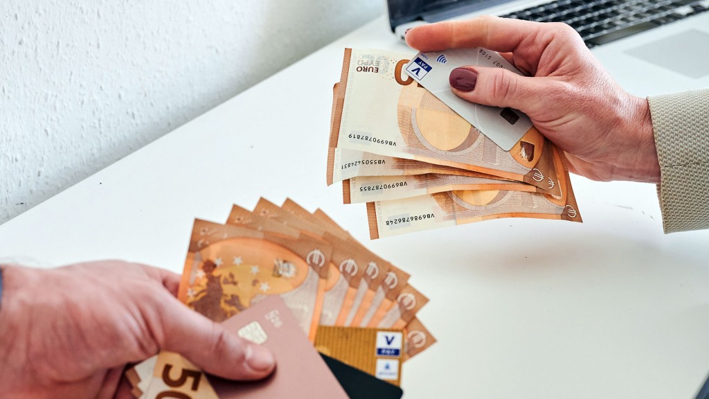 Foto:Ein mann und eine Frau halten unterschiedlich viele Geldscheine und Kreditkarten in der Hand