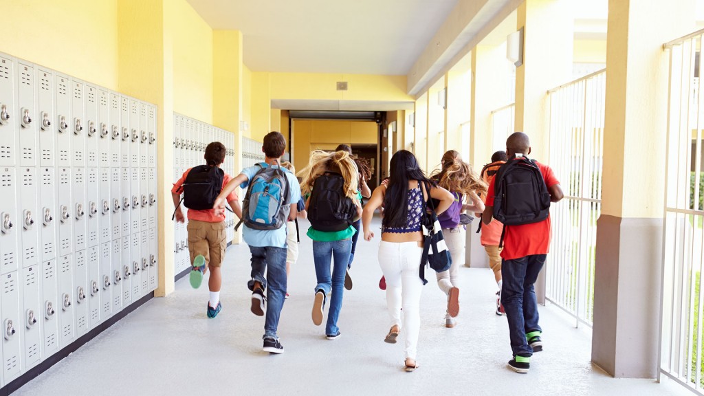 Foto: Mehrere Schülerinnen und Schüler laufen über den Flur zum Klassenraum