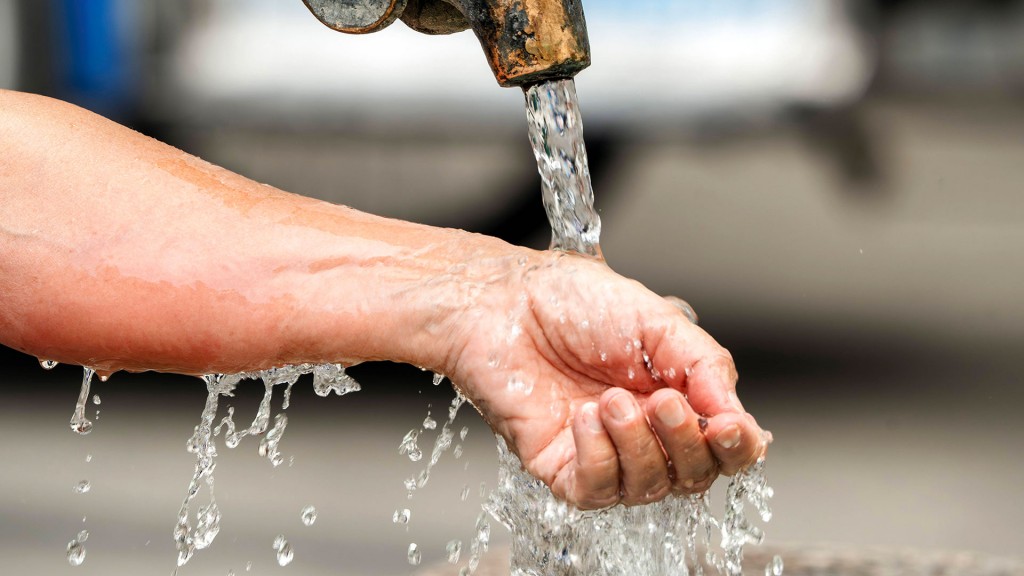 Frau lässt kaltes Wasser über ihr Handgelenk laufen