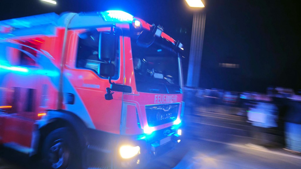 Foto: Ein Feuerwehrfahrzeug mit Blaulicht bei Nacht